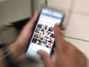 Redes sociais exibidas em um smartphone, com notas de dinheiro ao lado